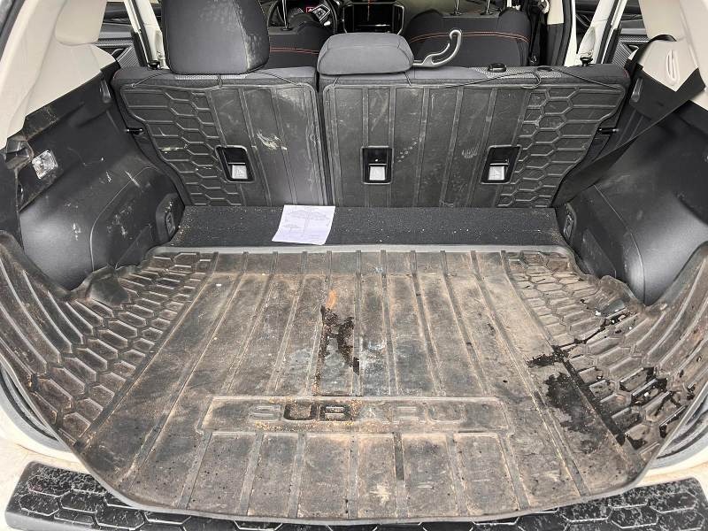 Before detailing: Subaru trunk showing dirt, debris, and stains on the floor and cargo area, in need of a professional cleaning to restore a tidy and fresh appearance