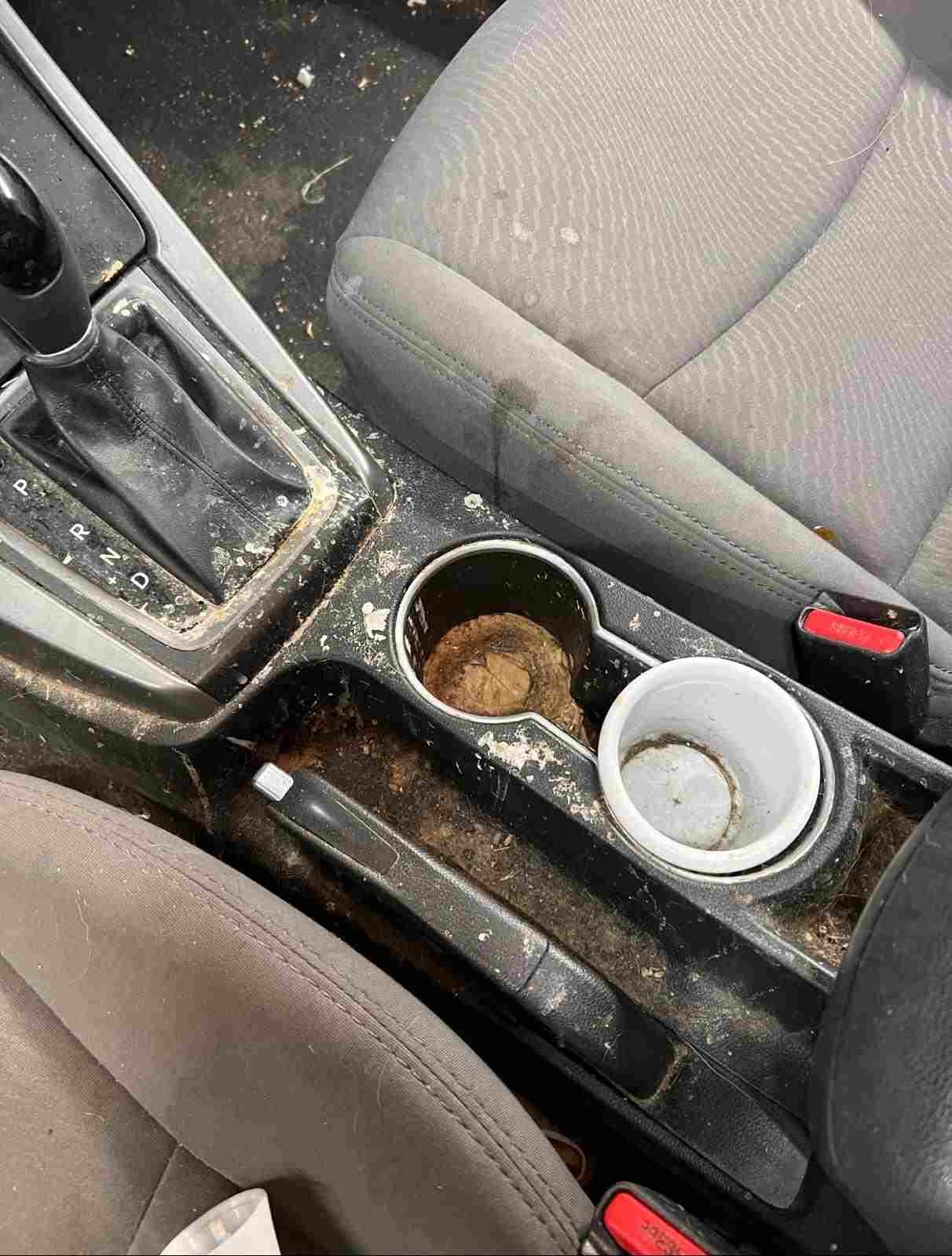 Before detailing: Interior center console showing heavy dirt, stains, and buildup, in need of professional cleaning and restoration to bring back its clean, polished, and like-new appearance